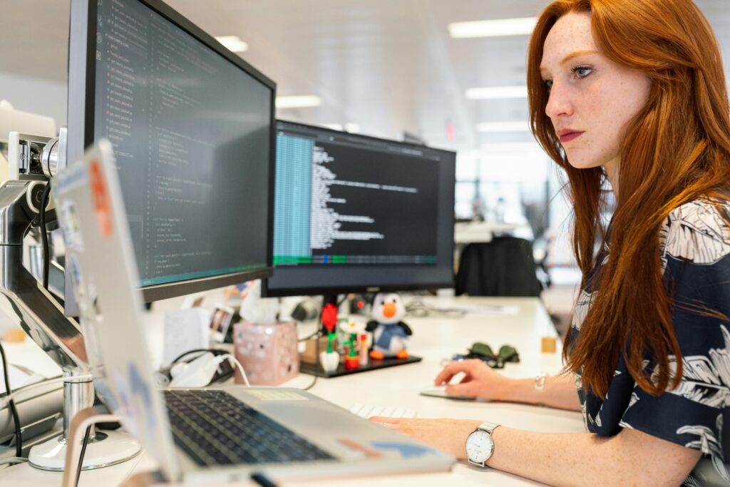 pexels photo 3861958 3861958 A focused female software engineer coding on dual monitors in a modern office.