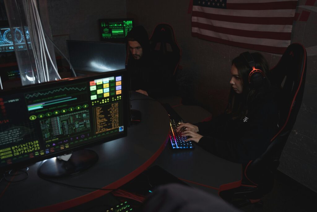 pexels photo 5380582 5380582 Cybersecurity professionals working on computer systems, focusing on data protection in a dimly lit room.