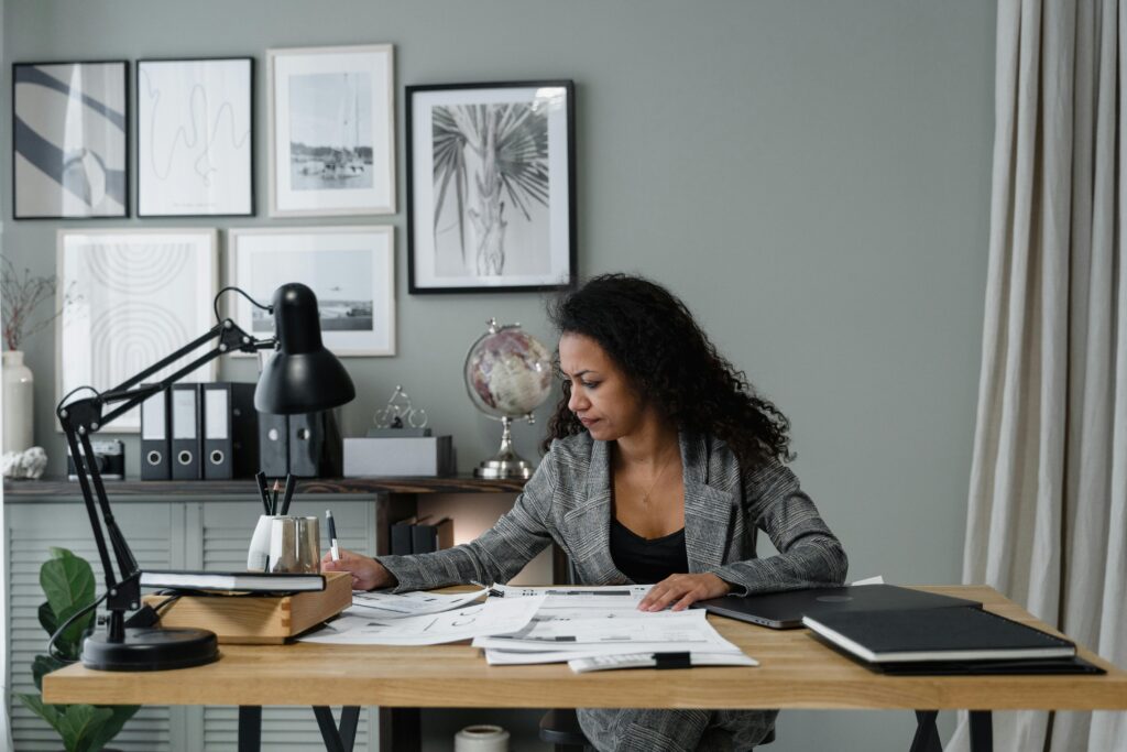 pexels photo 6694529 6694529 Businesswoman evaluates documents at a modern desk in a stylish office setting.