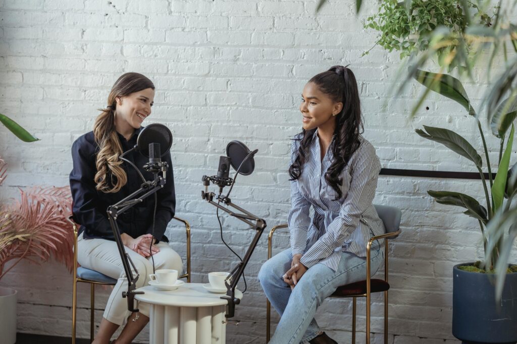 pexels photo 6953672 6953672 Diverse women communicating while recording voice in studio with white brick walls in daytime